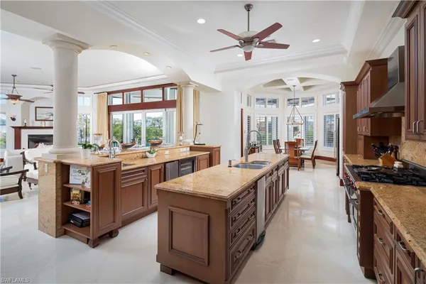 a large kitchen with stainless steel appliances granite countertop a large counter and chairs