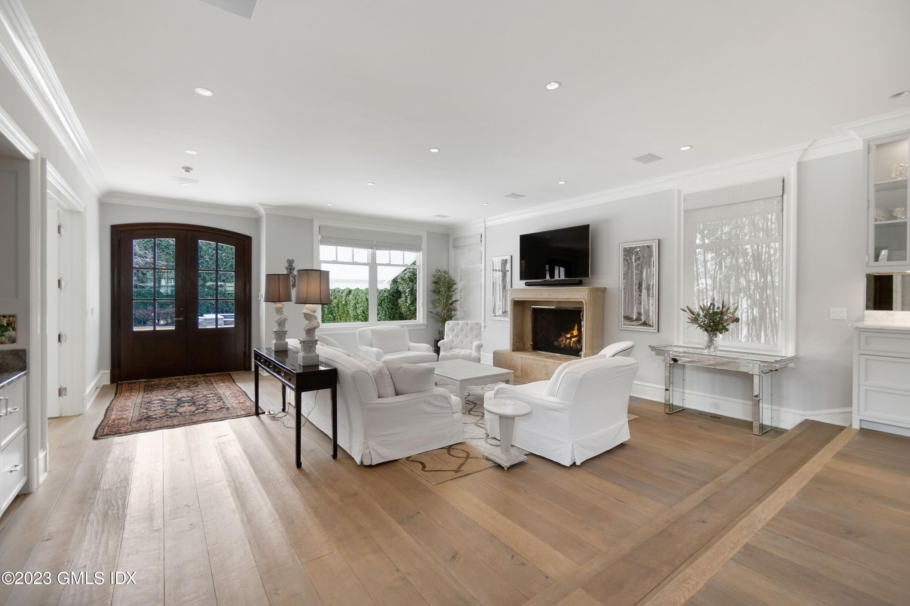6 Cherry Lane Old Greenwich, CT 06870 - Photo 9 of 31 a living room with furniture a fireplace and a flat screen tv