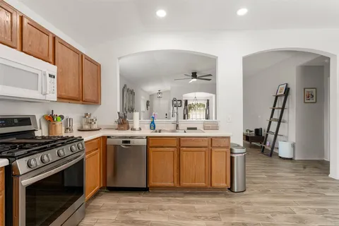 a kitchen with stainless steel appliances a stove a sink and a microwave