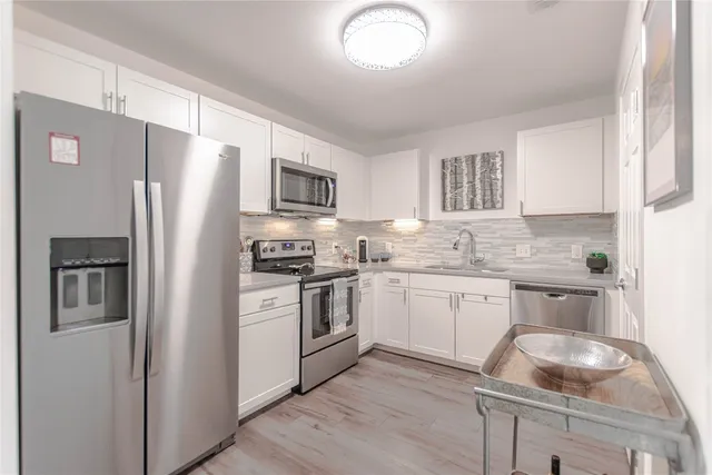 a kitchen with granite countertop a refrigerator stove and sink