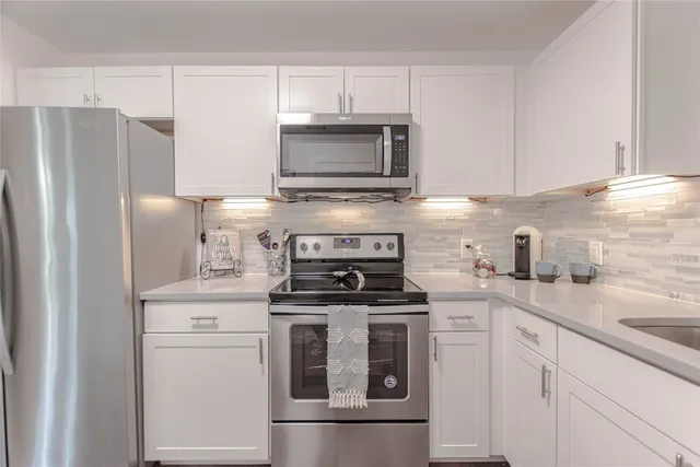 a kitchen with cabinets stainless steel appliances and a sink