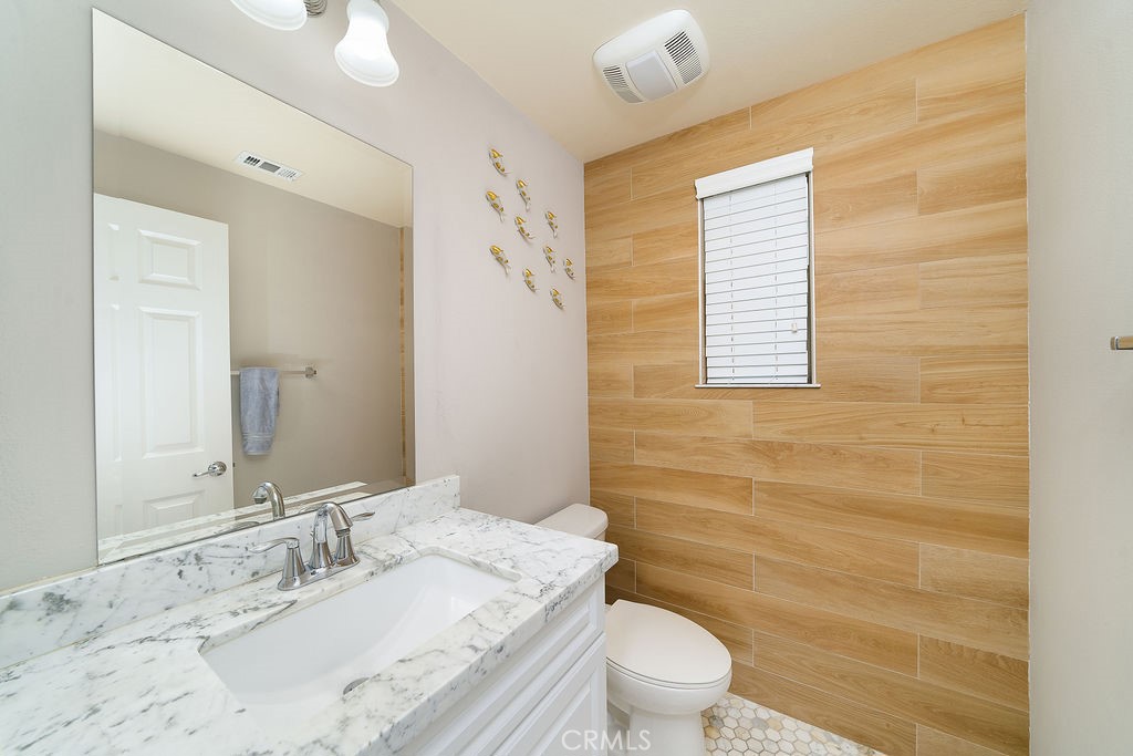60 Visionary Irvine, CA 92618 - Photo 13 of 30 a bathroom with a granite countertop toilet a sink a mirror and a shower