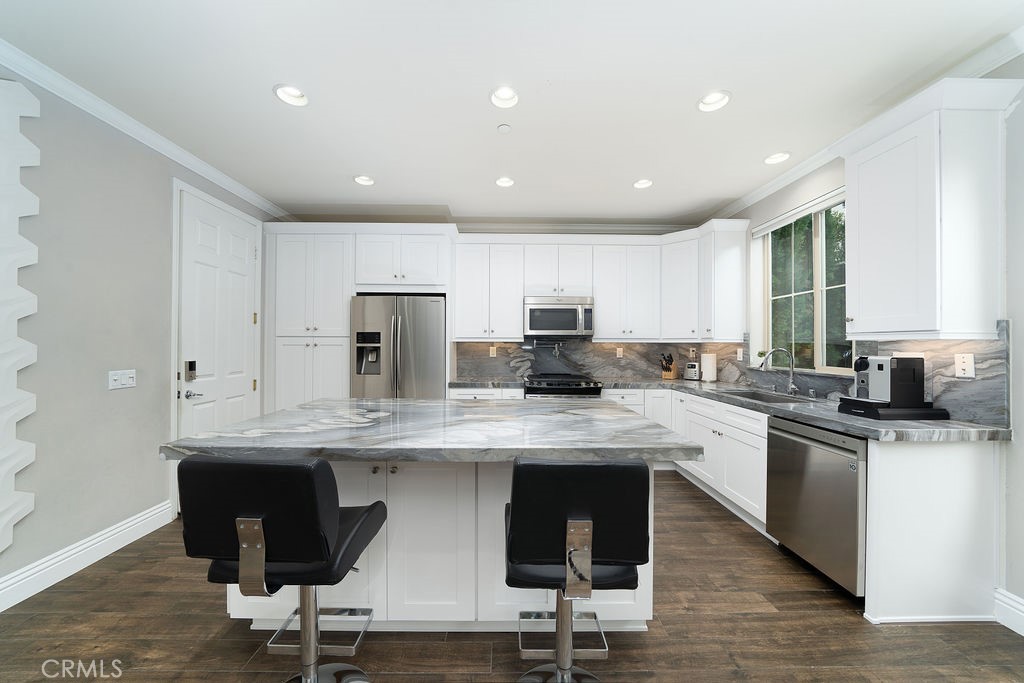 60 Visionary Irvine, CA 92618 - Photo 10 of 30 a kitchen with stainless steel appliances granite countertop a table chairs sink refrigerator and cabinets