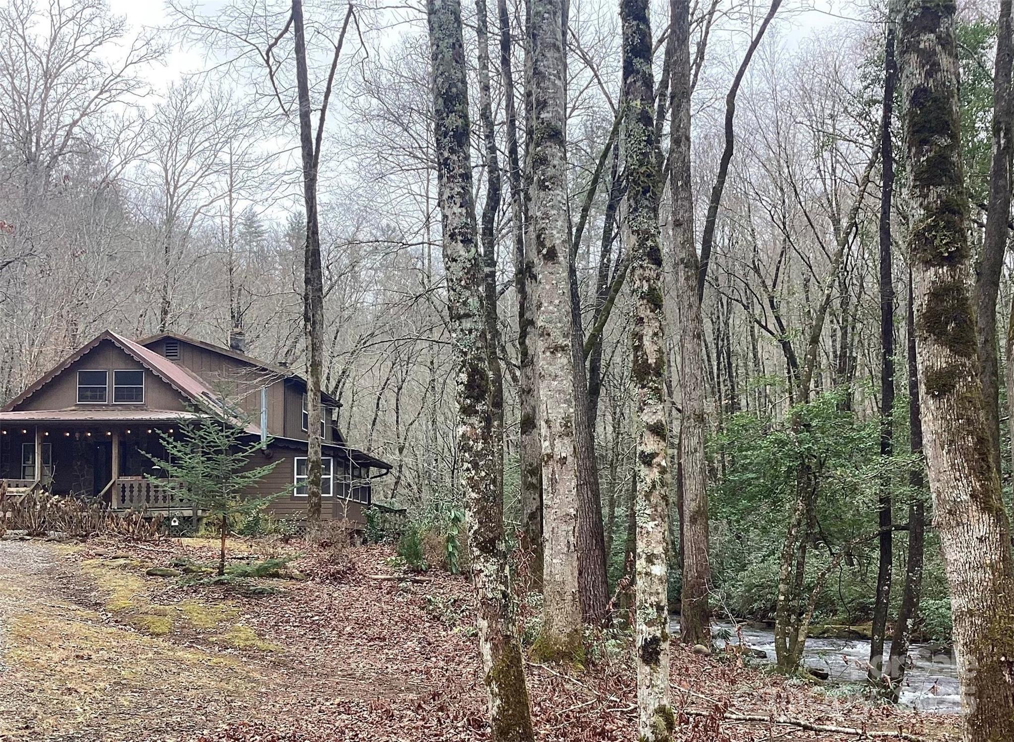 4700 West Buffalo Road Robbinsville, NC 28771 - Photo 11 of 25 a backyard of a house with table and chairs under an umbrella