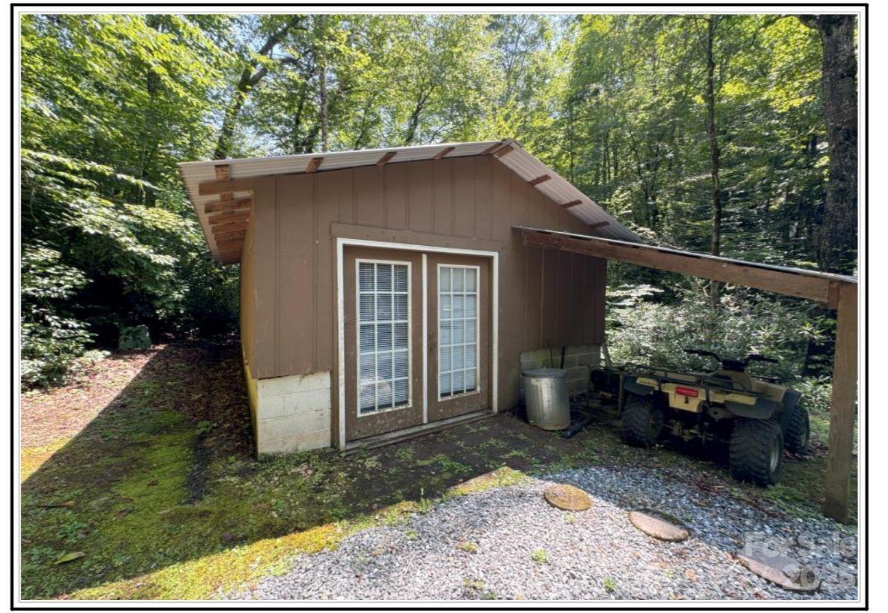 4700 West Buffalo Road Robbinsville, NC 28771 - Photo 16 of 25 a backyard of a house with barbeque oven fire pit table and chairs