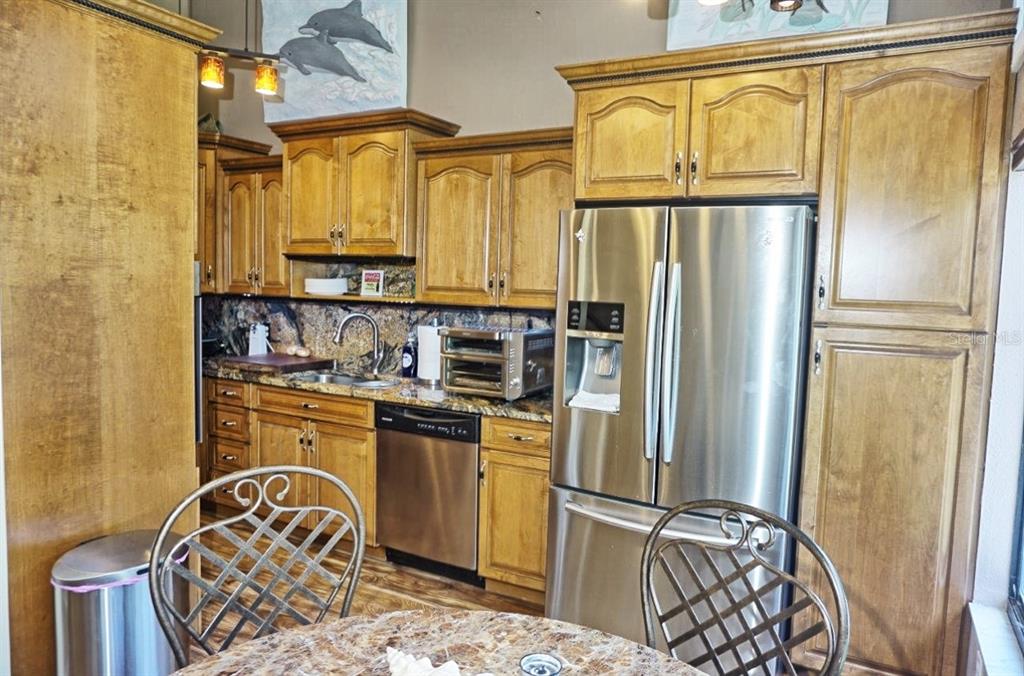 1873 Mazo Manor Road, Unit 5 Lutz, FL 33558 - Photo 14 of 41 a kitchen with stainless steel appliances granite countertop a refrigerator a stove and a sink with wooden floor