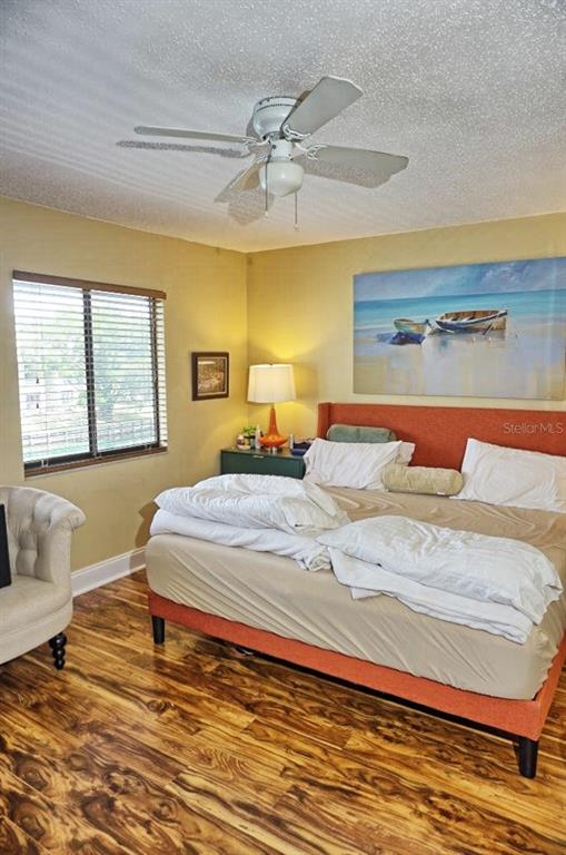 1873 Mazo Manor Road, Unit 5 Lutz, FL 33558 - Photo 21 of 41 a bedroom with a large bed and a chandelier