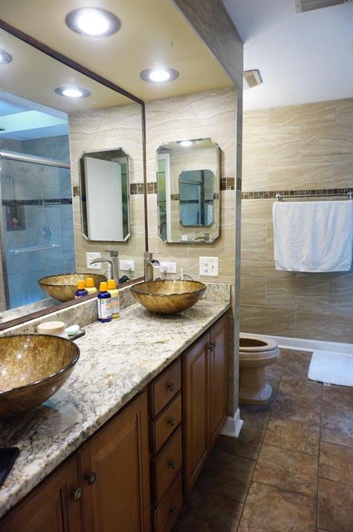 1873 Mazo Manor Road, Unit 5 Lutz, FL 33558 - Photo 25 of 41 a bathroom with a granite countertop toilet sink and mirror