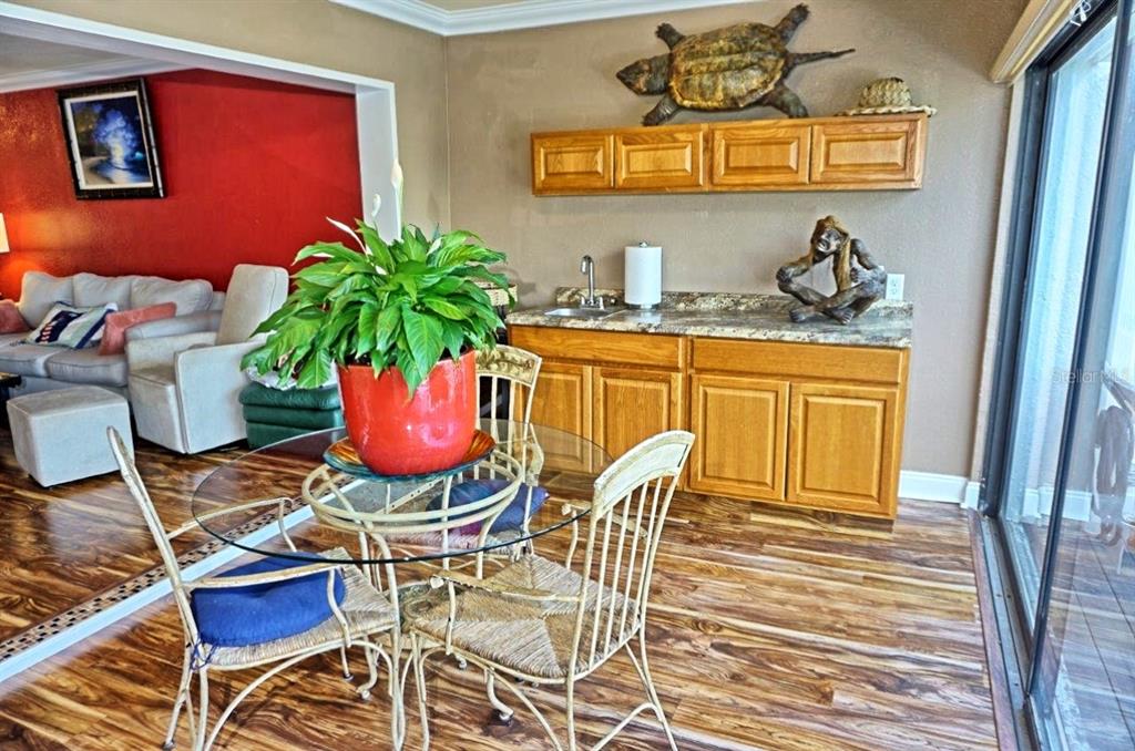 1873 Mazo Manor Road, Unit 5 Lutz, FL 33558 - Photo 6 of 41 a dining room with furniture potted plants and wooden floor
