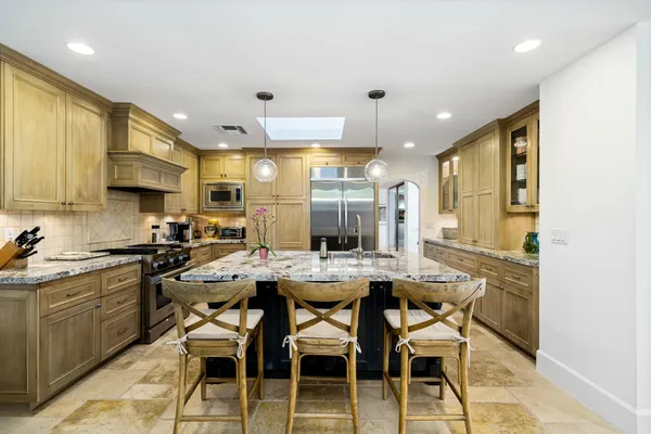 a kitchen with stainless steel appliances kitchen island granite countertop a sink and cabinets