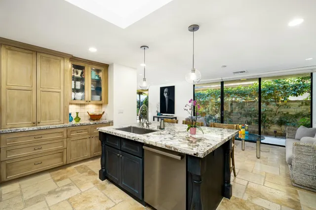 a open kitchen with kitchen island granite countertop a sink and a stove with granite countertops