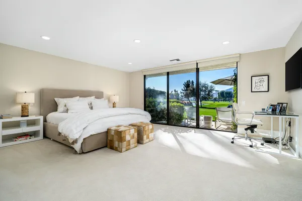 a spacious bedroom with a bed and large mirror