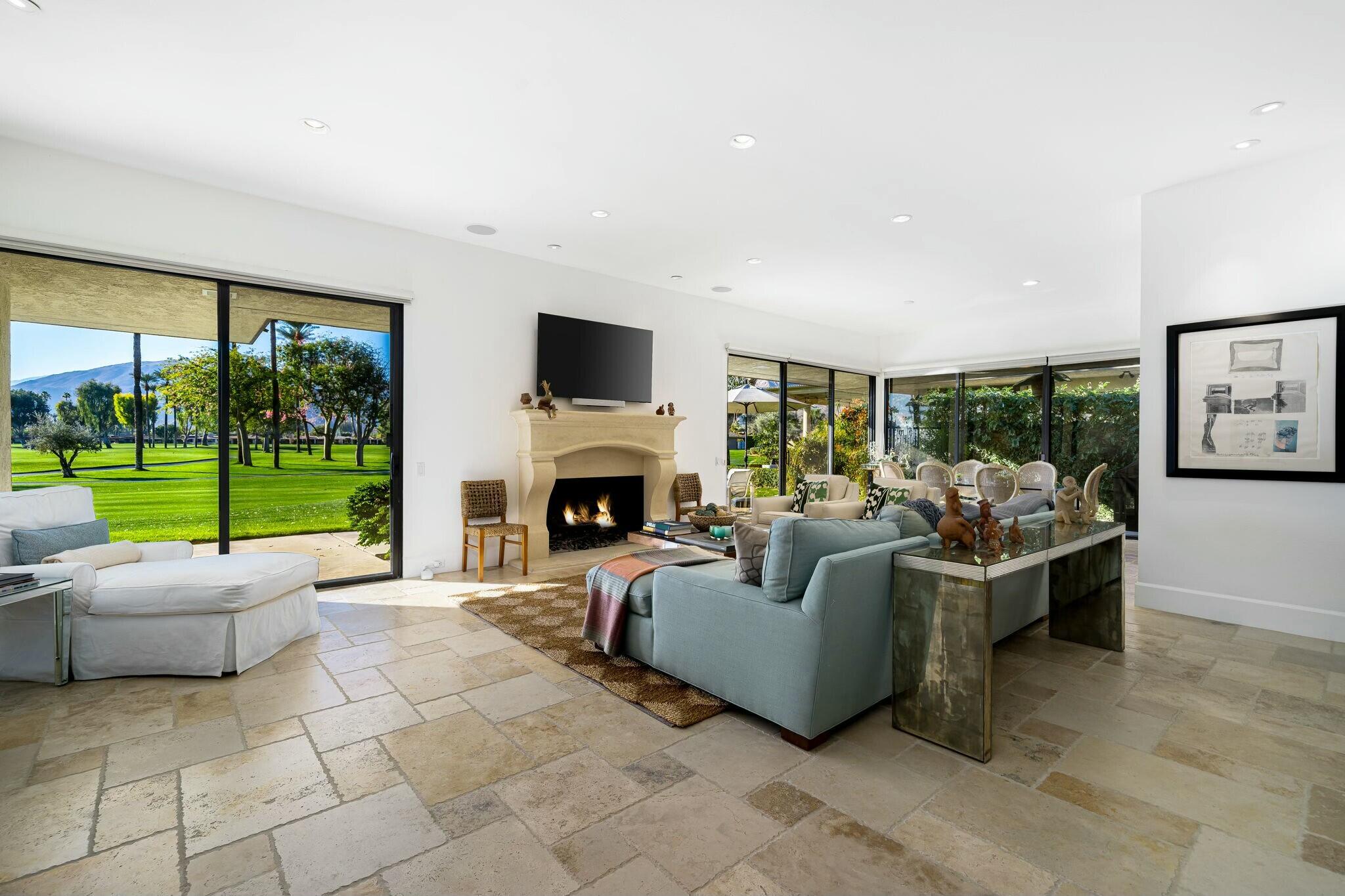 7 Princeton Drive Rancho Mirage, CA 92270 - Photo 2 of 39 a living room with furniture a fireplace and a floor to ceiling window