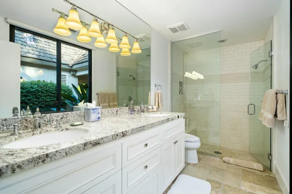 a bathroom with a granite countertop sink toilet and shower