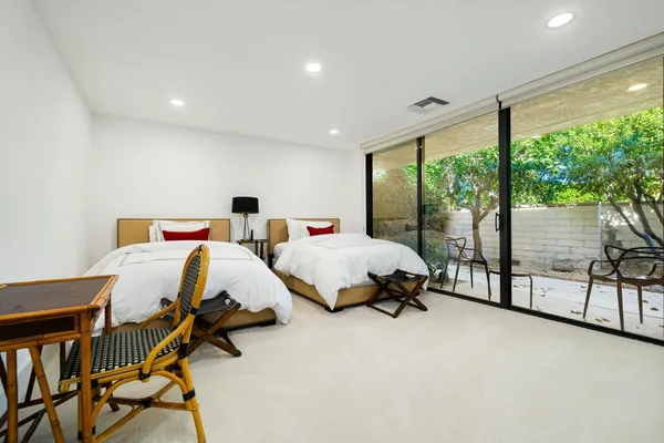 a bed room with two bed and large windows