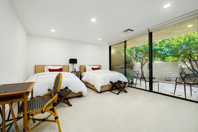 a bed room with two bed and large windows