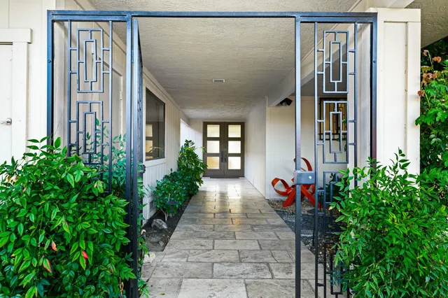 a front view of a house with backyard and trees