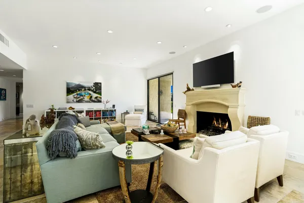 a living room with furniture a flat screen tv and a fireplace