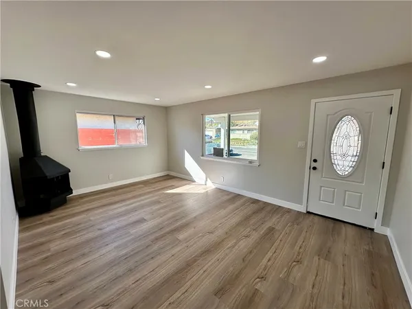 a view of empty room with window and wooden floor