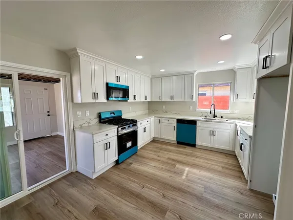 a kitchen with granite countertop a refrigerator stove top oven and sink