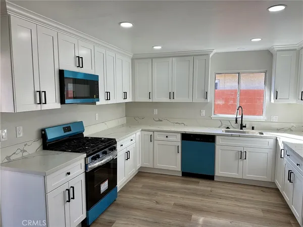 a kitchen with stainless steel appliances granite countertop a stove a sink and a microwave
