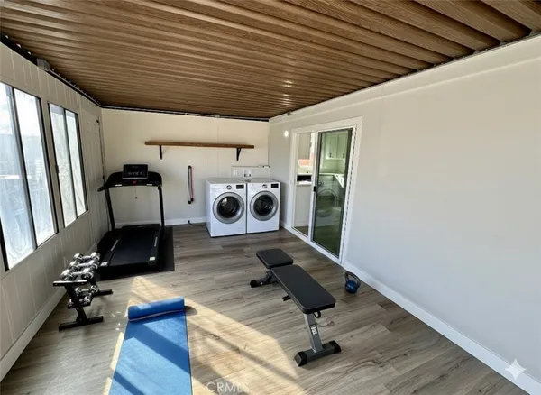 a room with gym equipment and wooden floor