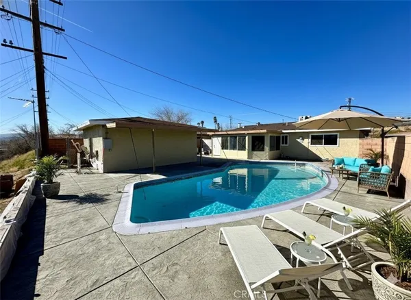 a view of a house with backyard sitting area and swimming pool