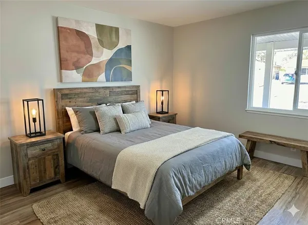 a bedroom with a bed and painting on the wall