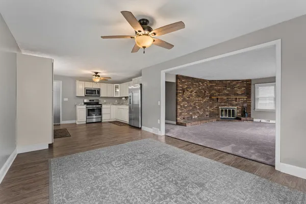 a view of a livingroom with a ceiling fan hardwood floor and a ceiling fan