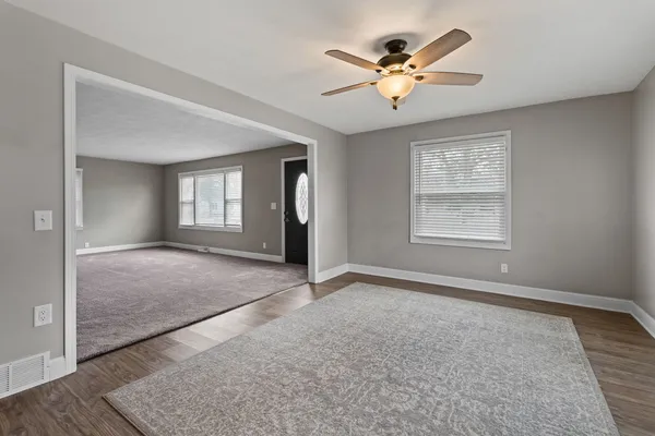 an empty room with fan and windows