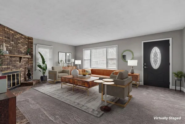 a living room with furniture a fireplace and a large window