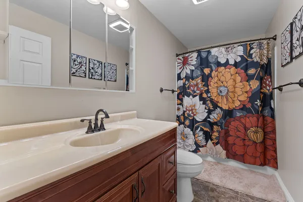 a bathroom with a sink a toilet and shower curtain