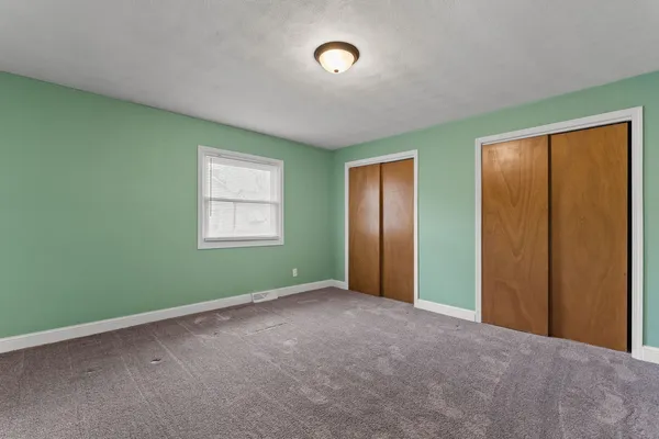 an empty room with windows and closet