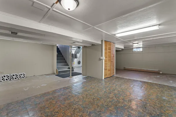 a view of an empty room with closet and a window