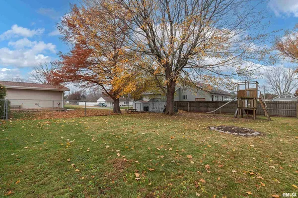 a view of backyard with wooden fence and a large tree