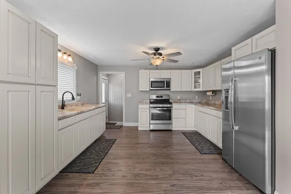 a kitchen with white cabinets and stainless steel appliances