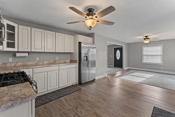 a kitchen with granite countertop a stove a sink and a refrigerator