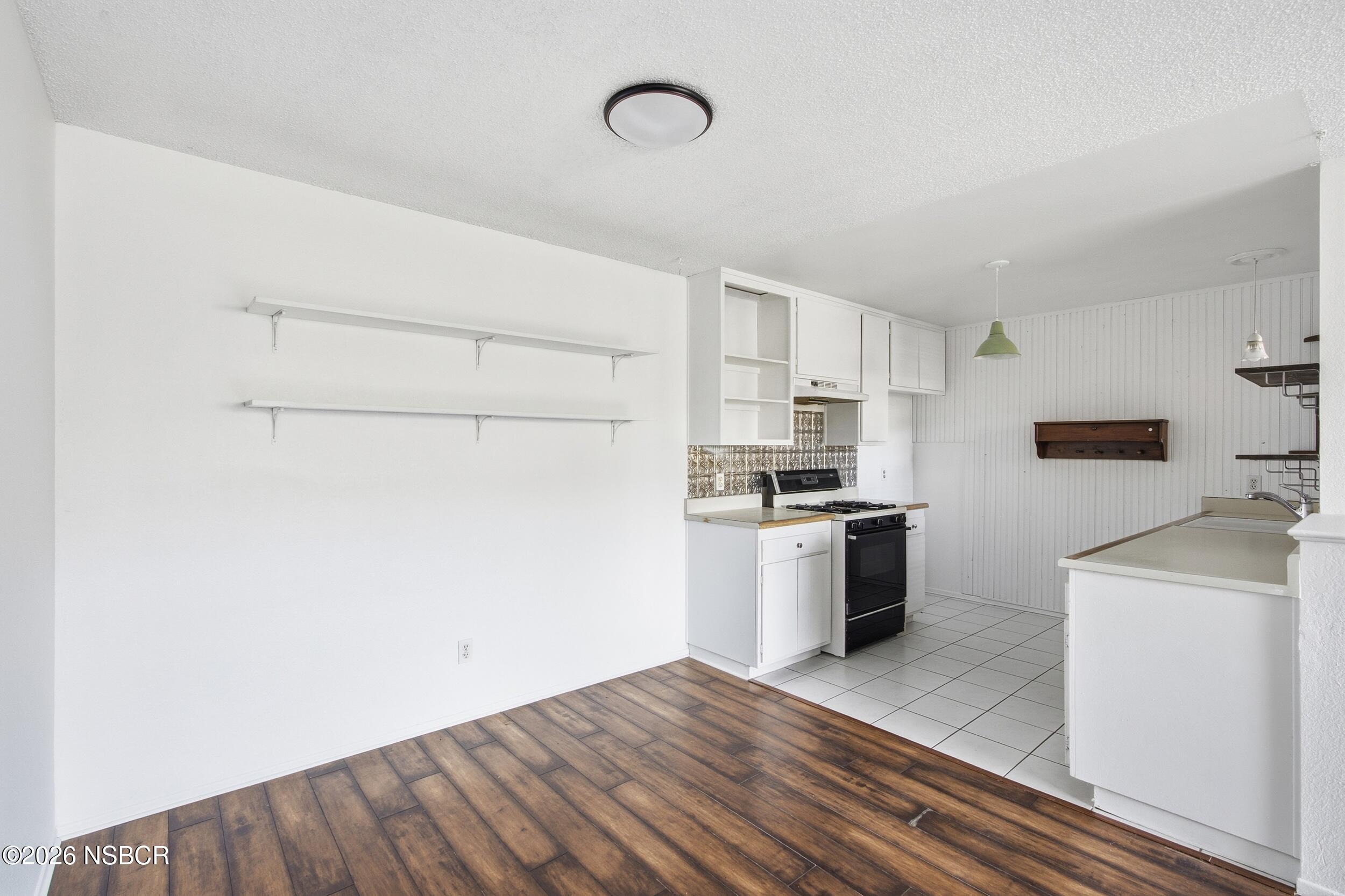 3350 Santa Maria Way, Unit 104A Santa Maria, CA 93455 - Photo 10 of 23 a kitchen with a refrigerator stove and white cabinets