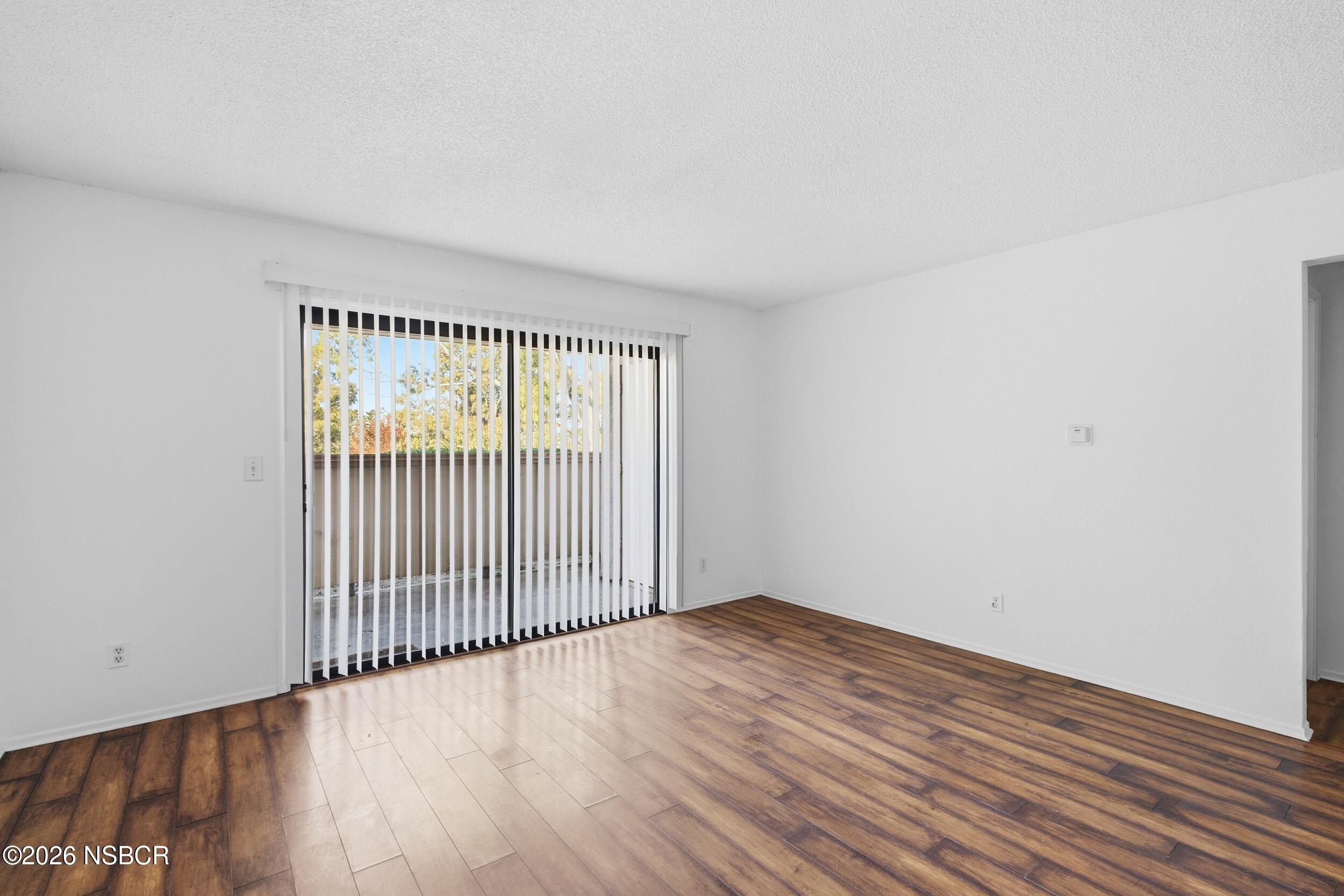3350 Santa Maria Way, Unit 104A Santa Maria, CA 93455 - Photo 5 of 23 an empty room with wooden floor and windows