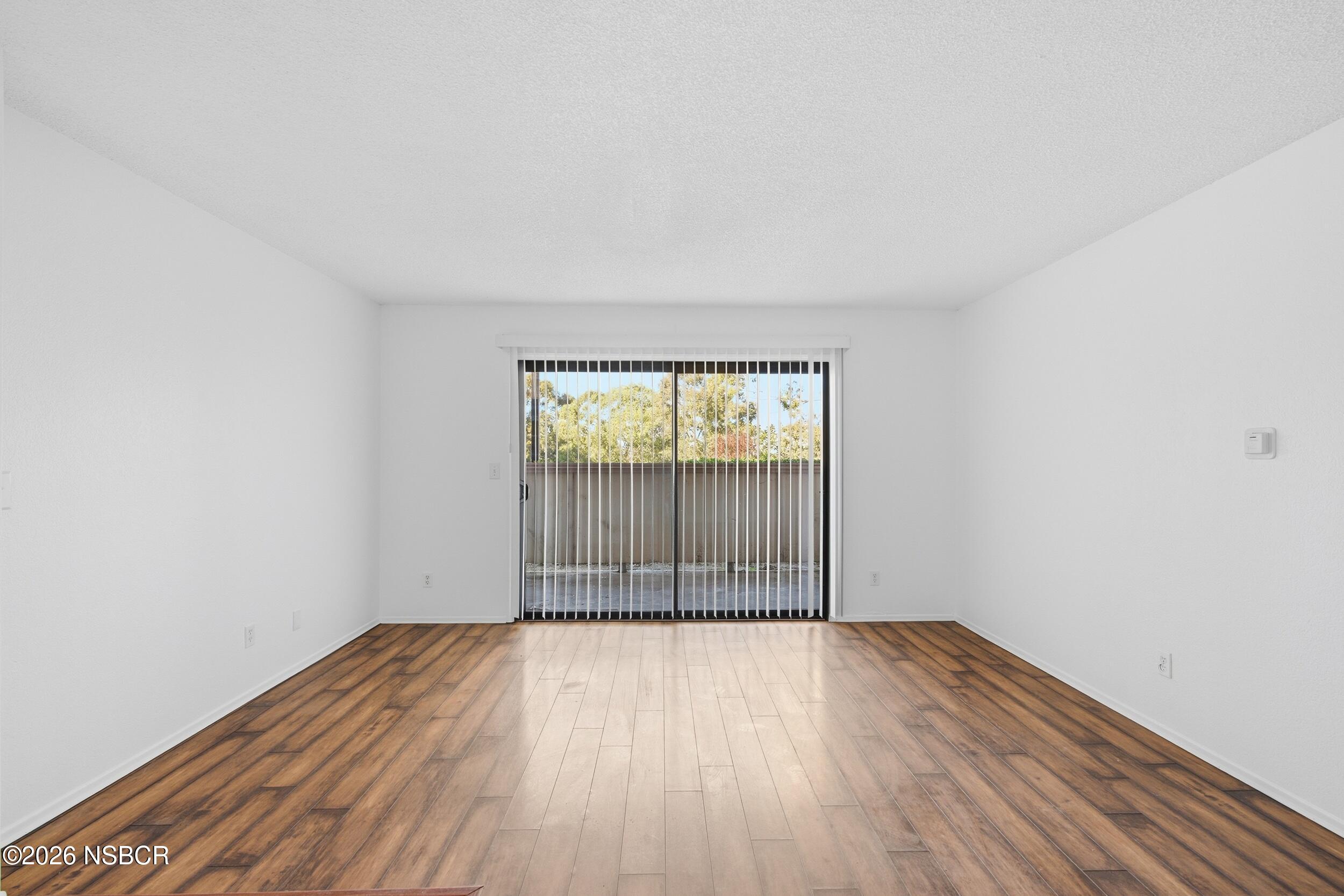 3350 Santa Maria Way, Unit 104A Santa Maria, CA 93455 - Photo 8 of 23 an empty room with wooden floor and windows
