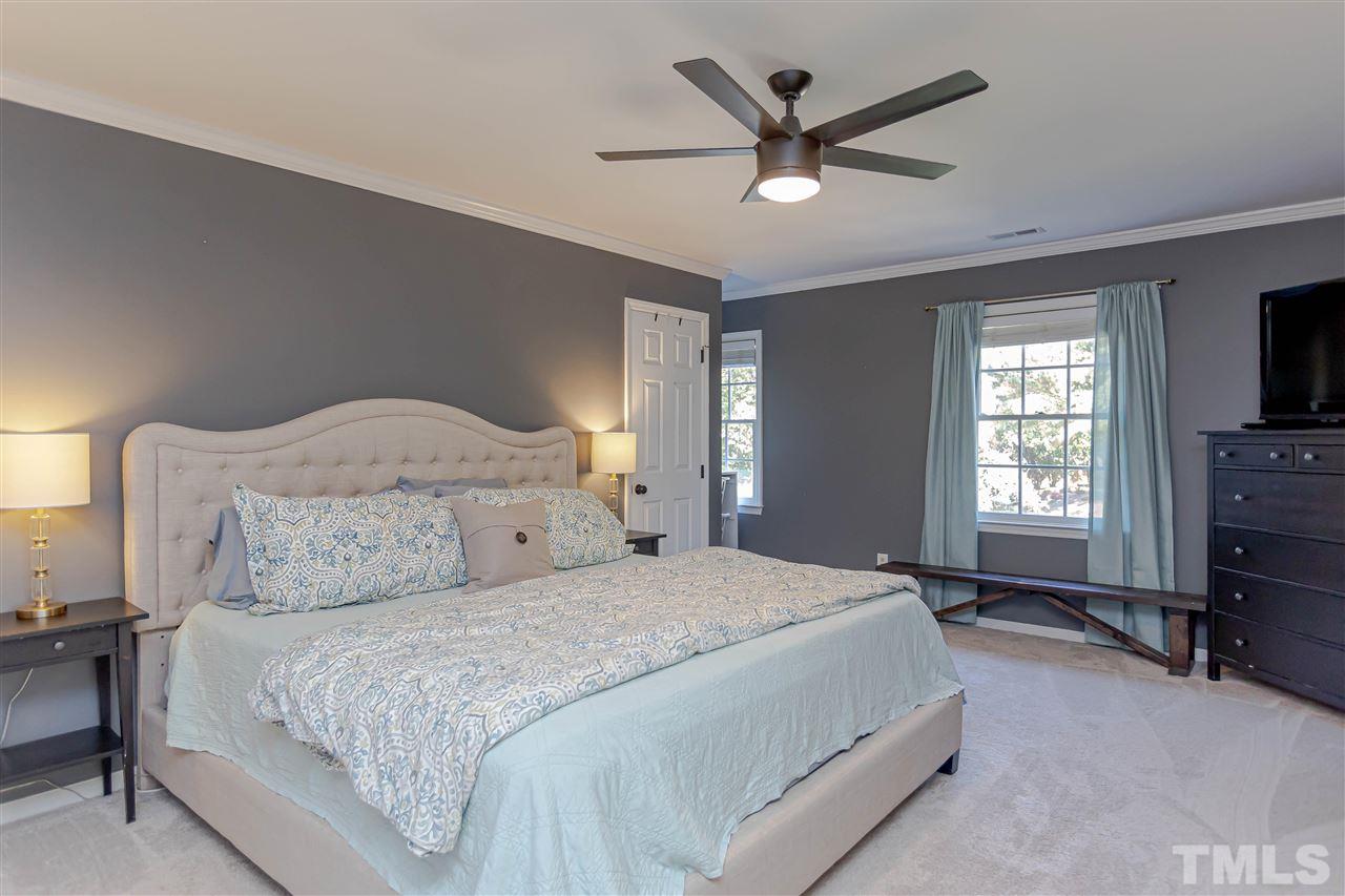 1212 Oakside Court Raleigh, NC 27609 - Photo 17 of 25 a bedroom with a bed a window and a television