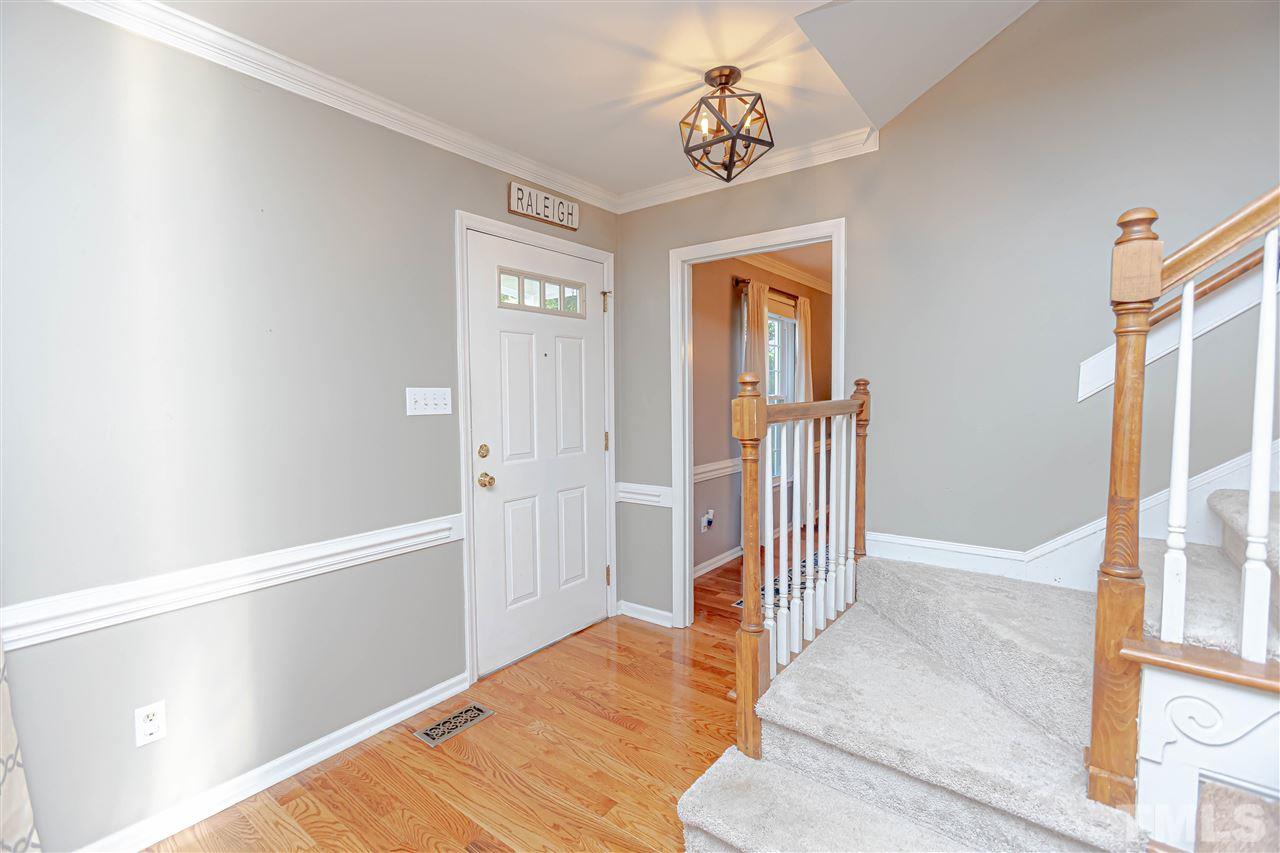 1212 Oakside Court Raleigh, NC 27609 - Photo 3 of 25 a view of a hallway with wooden floor and livingroom