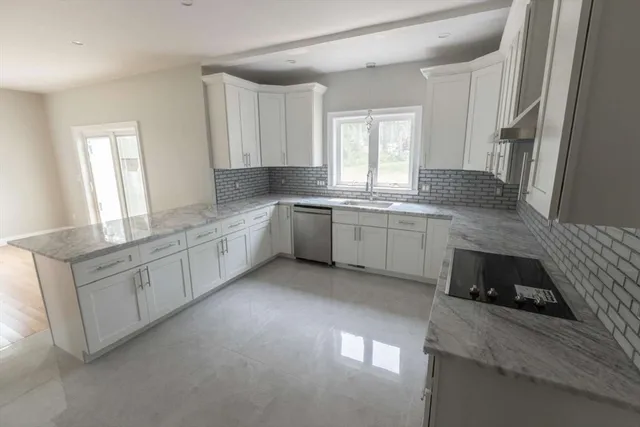 a kitchen with granite countertop white cabinets and white appliances