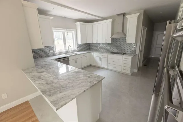 a kitchen with stainless steel appliances granite countertop a sink refrigerator and cabinets