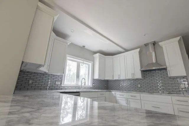 a view of a kitchen with granite countertop white cabinets and a window