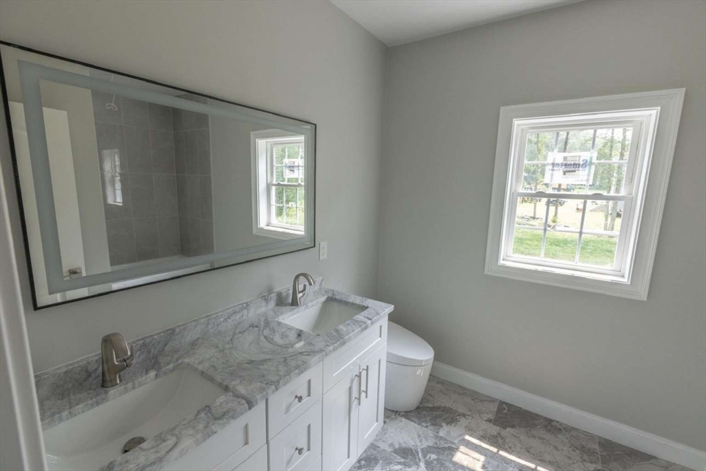217 Prospect Street Auburn, MA 01501 - Photo 16 of 41 a bathroom with a granite countertop sink toilet and mirror