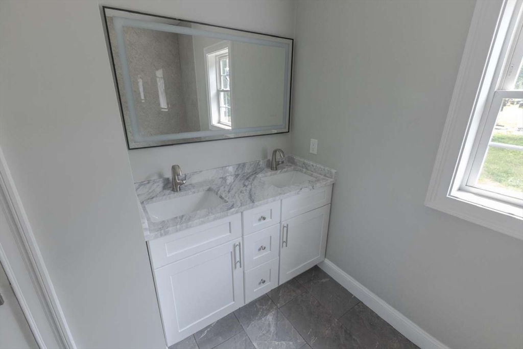 217 Prospect Street Auburn, MA 01501 - Photo 19 of 41 a bathroom with a granite countertop sink and a mirror