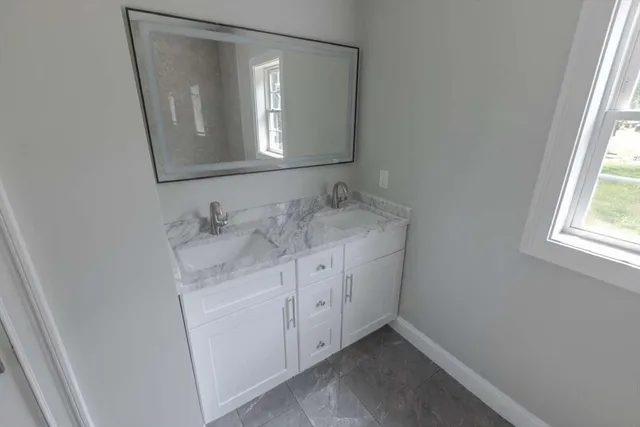 a bathroom with a granite countertop sink and a mirror