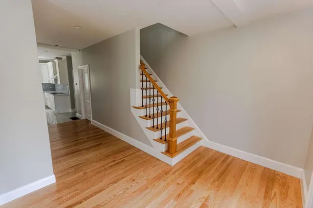 a view of a hallway with wooden floor and staircase
