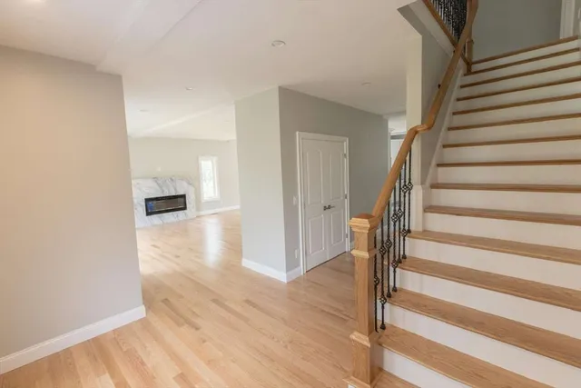 a view of a hallway with wooden floor and staircase